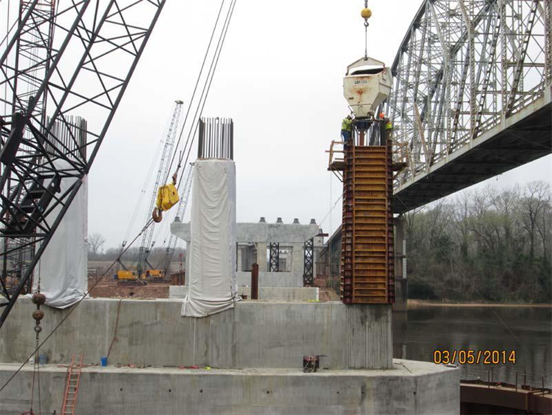 These are 2 workers inside the columm forms vibrating the concrete
